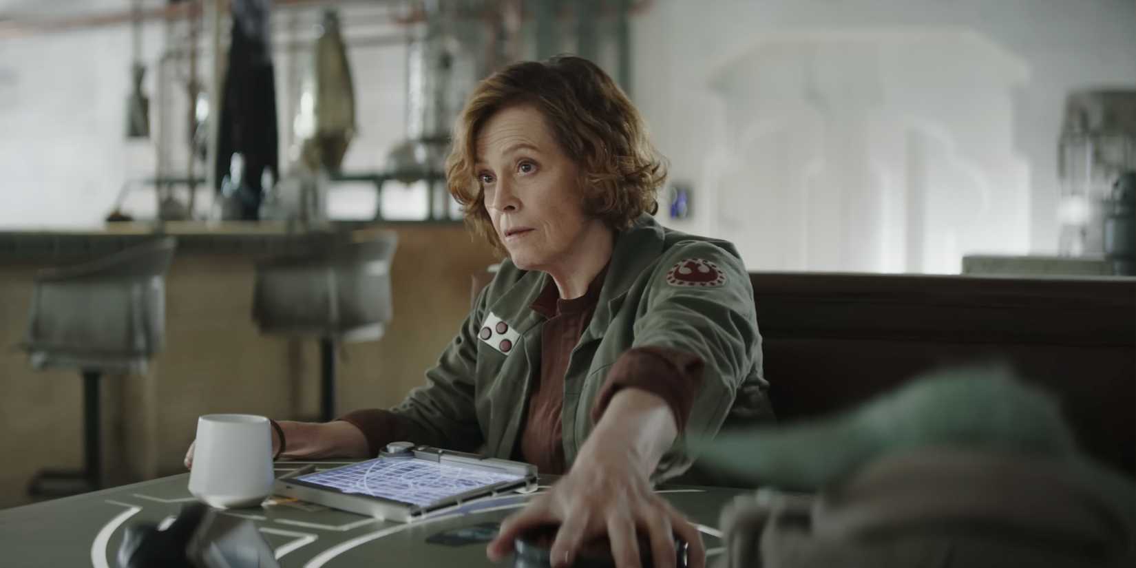 Colonel Ward (Sigourney Weaver) segura um pote de petiscos para Grogu.