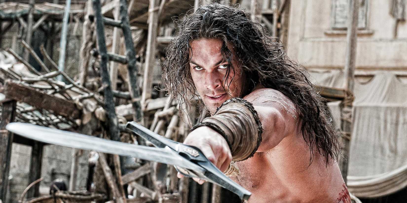 Jason Momoa shirtless and pointing a sword in Conan the Barbarian