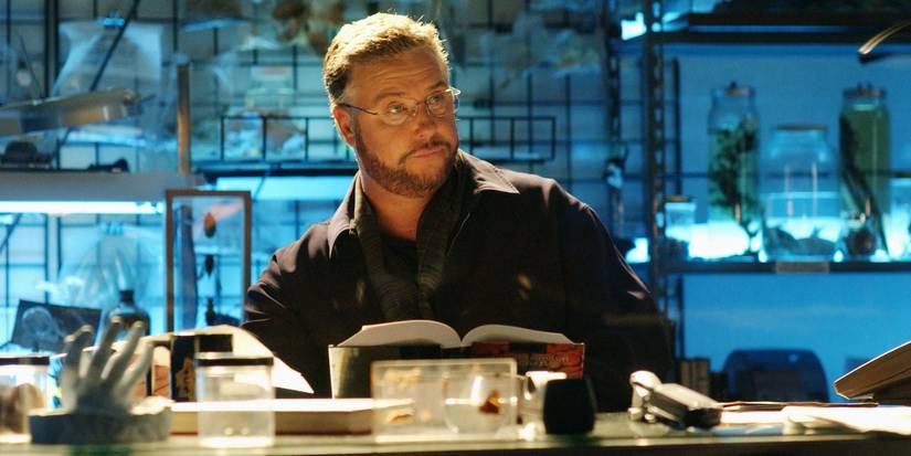 Gil Grissom (William Petersen) with a book in front of him in the lab in CSI