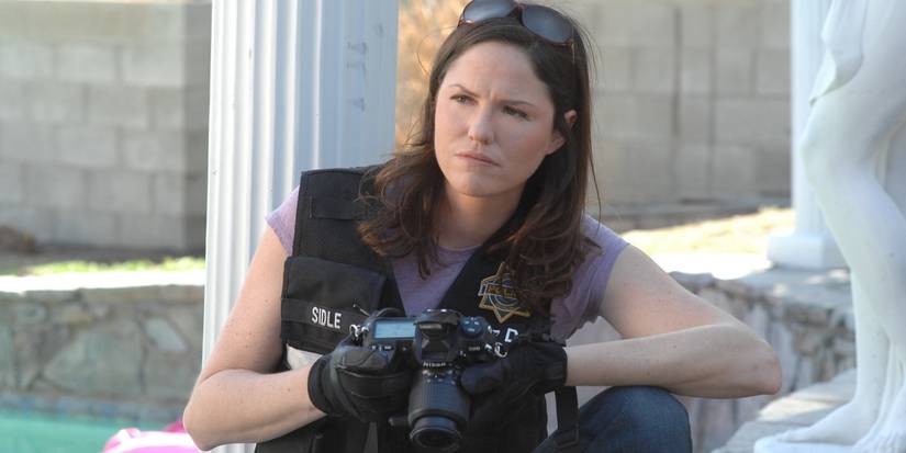 Sara Sidle (Jorja Fox) with a camera at a crime scene in CSI