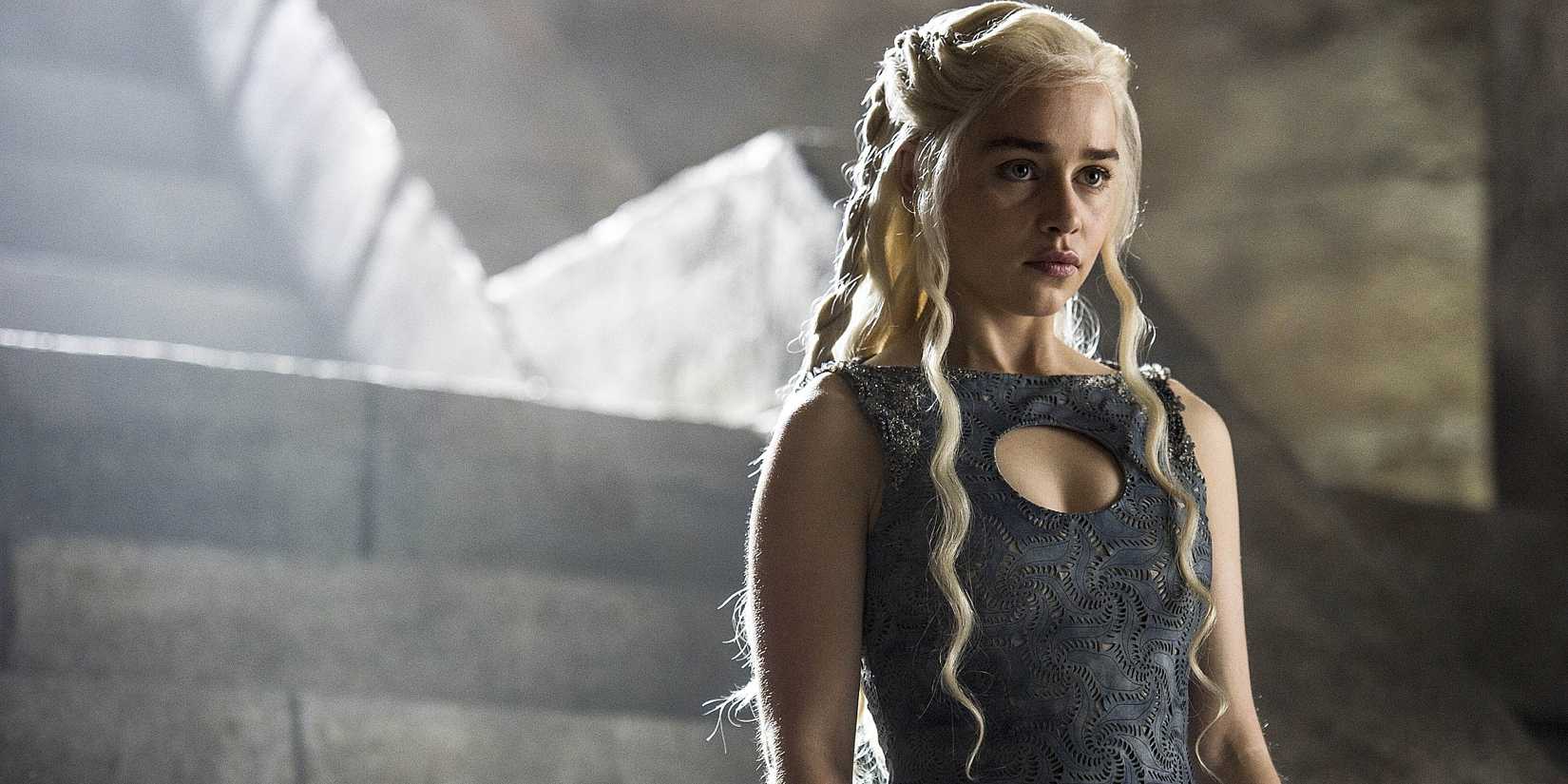 Emilia Clarke como Daenerys Targaryen com uma expressão séria em Game of Thrones.