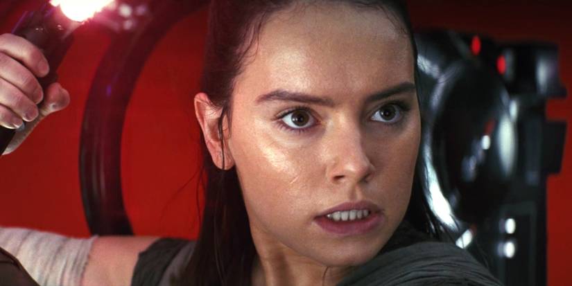 Daisy Ridley as Rey holding a red lightsaber in The Last Jedi