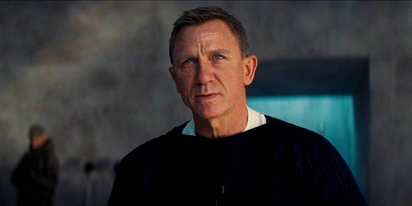 Daniel Craig looking up with a tense, wry expression as James Bond in No Time to Die