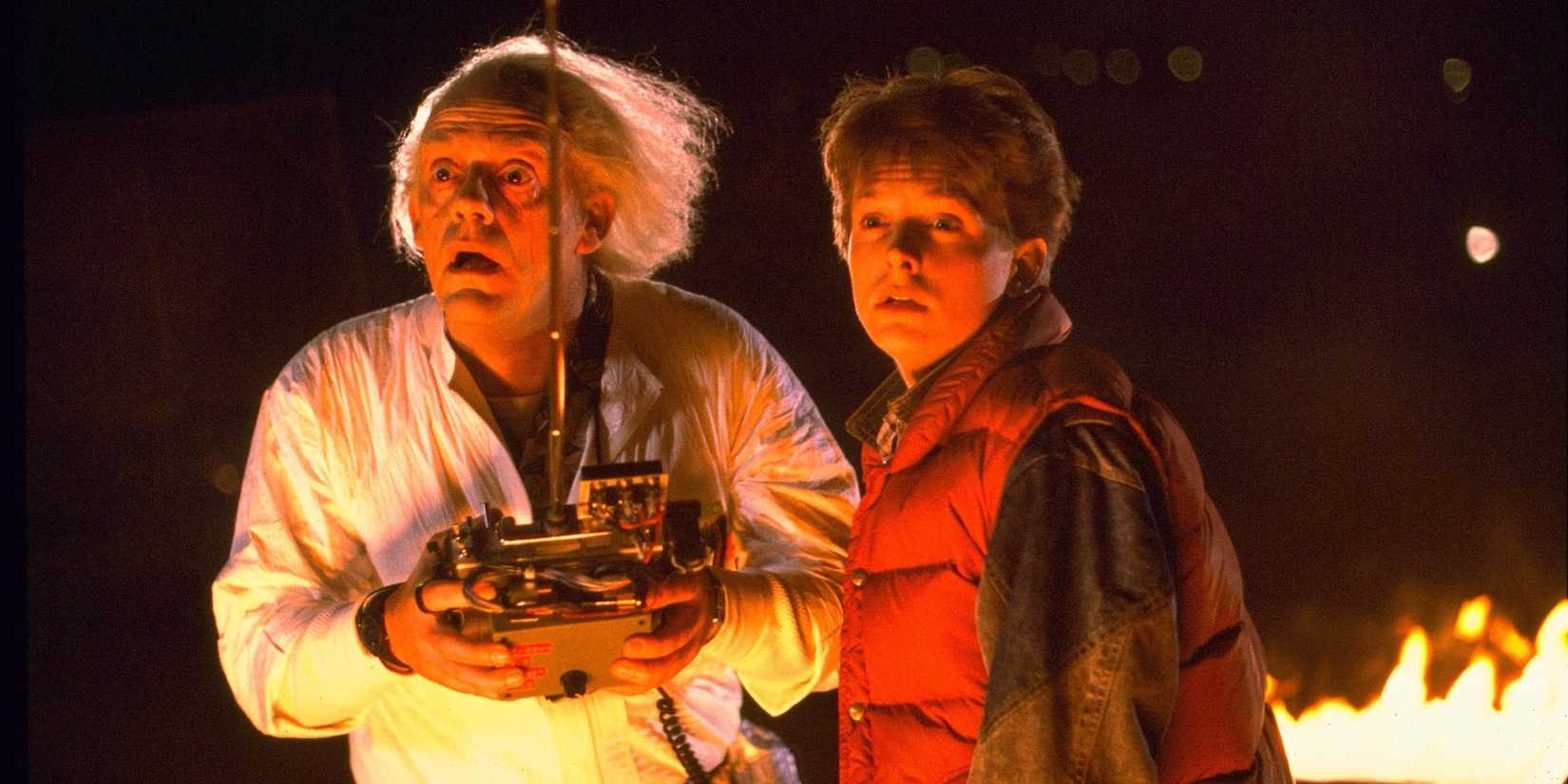 Doc e Marty parecem chocados e são iluminados por chamas em De Volta Para o Futuro.