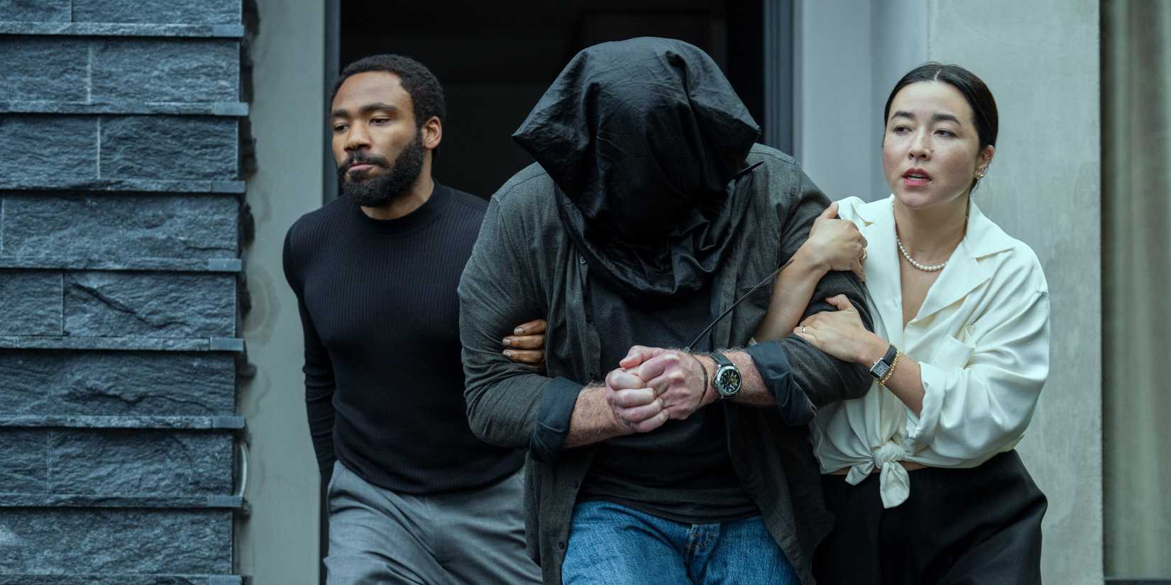 John Smith, played by Donald Glover, and Jane Smith, played by Maya Erskine, take Ron Perlman's character hostage in season 1 of Mr. & Mrs. Smith.