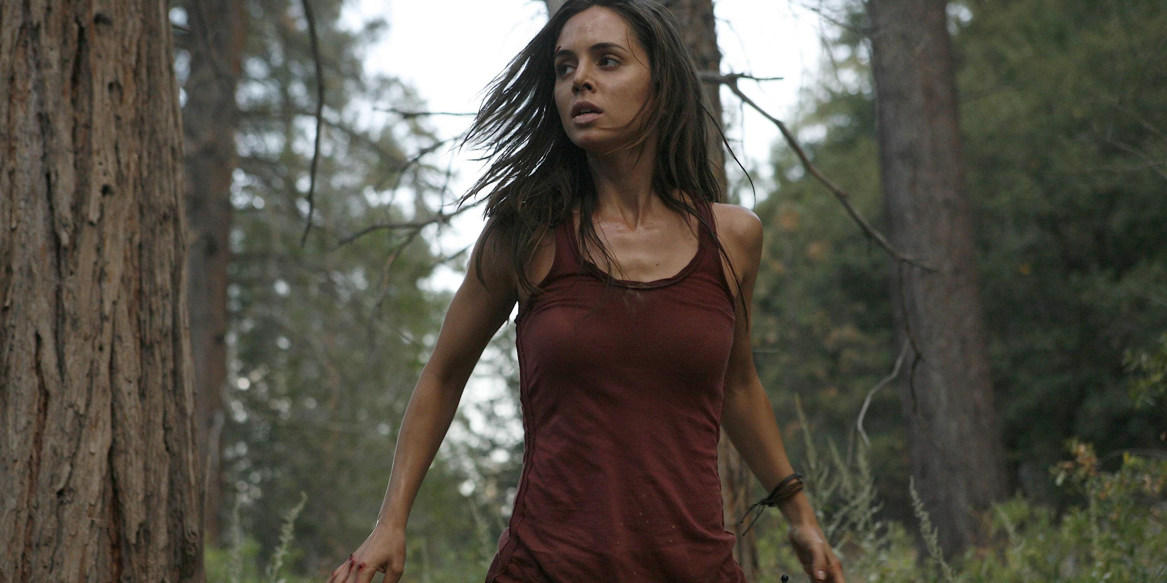 Eliza Dushku come EchoCaroline Farrell con espressione intensa nel mezzo dei boschi
