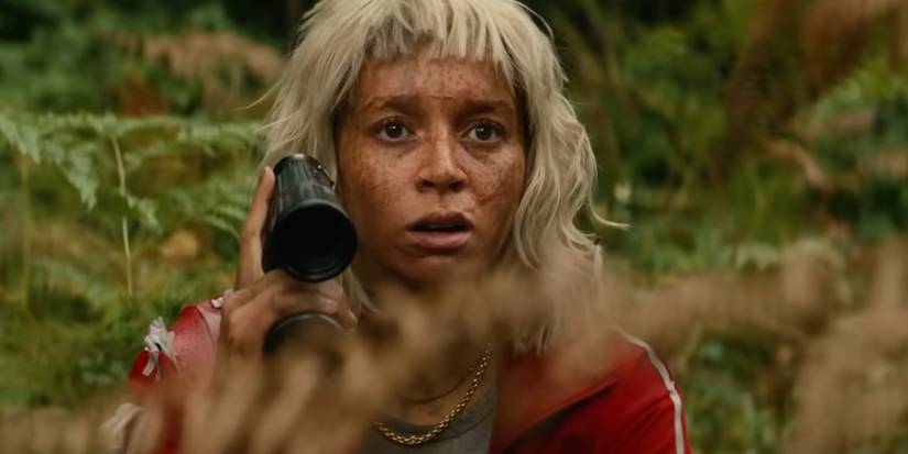 Erin Kellyman as Jimmy Ink looking scared and holding binoculars in 28 Years Later The Bone Temple