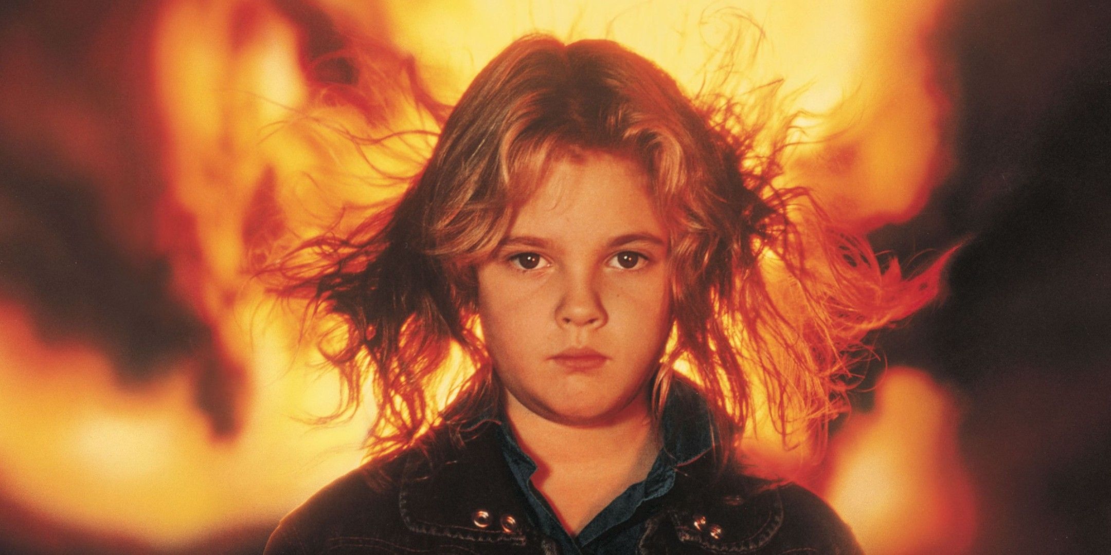 Drew Barrymore looks on blankly with her hair flying in Firestarter