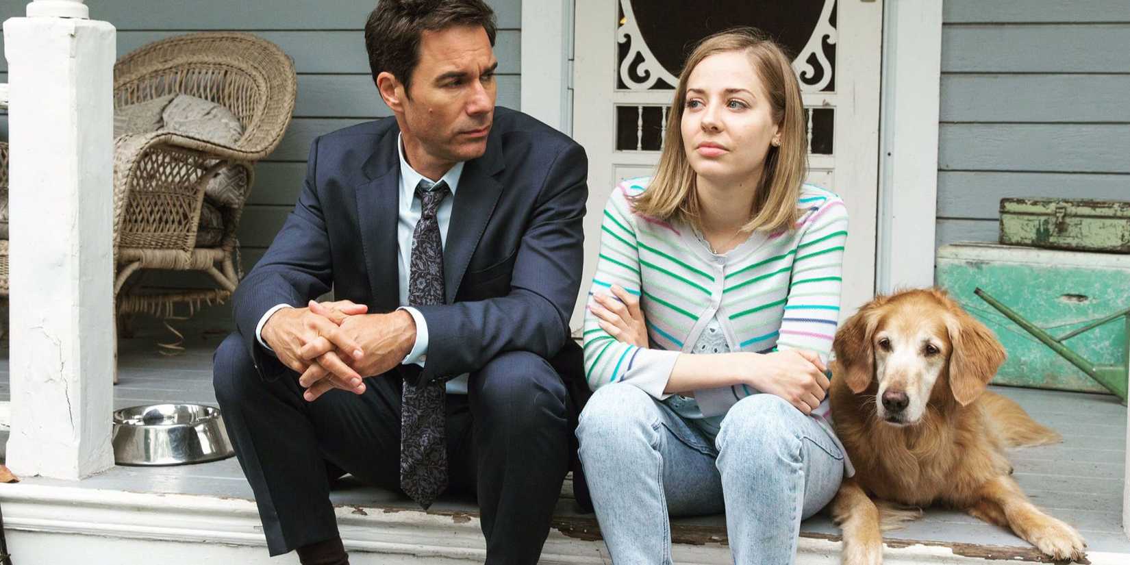 Grant McLaren e Marcy Warton sentados em degraus com seu cachorro na série Travelers