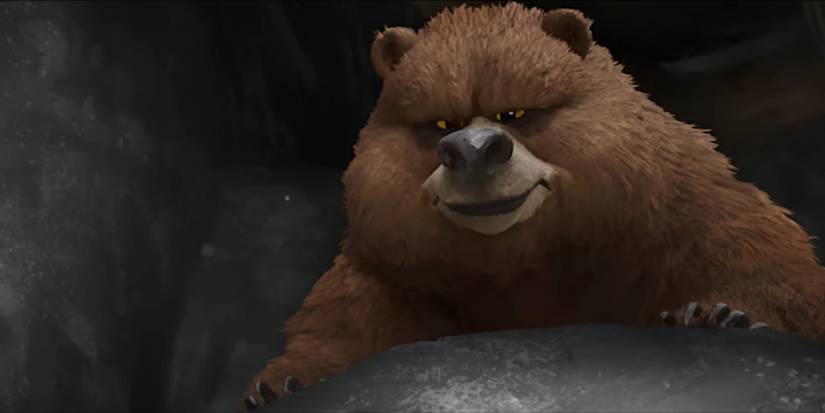 Grizzy bear Thorn peers menacingly over a rock in a scene from The Wild Robot