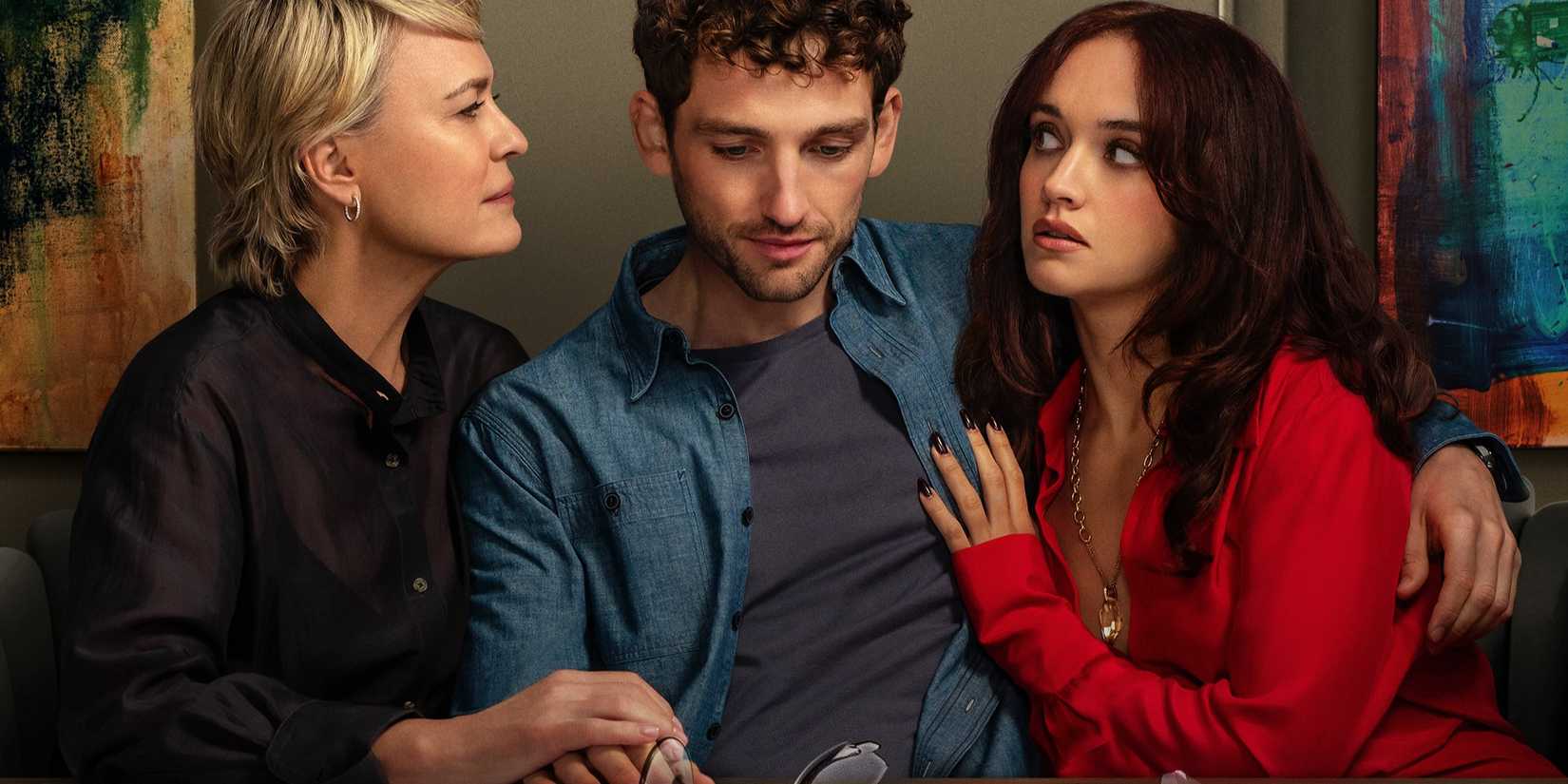 Daniel sits in between Laura and Cherry, holding Laura's hand and putting his arm around Cherry, in The Girlfriend