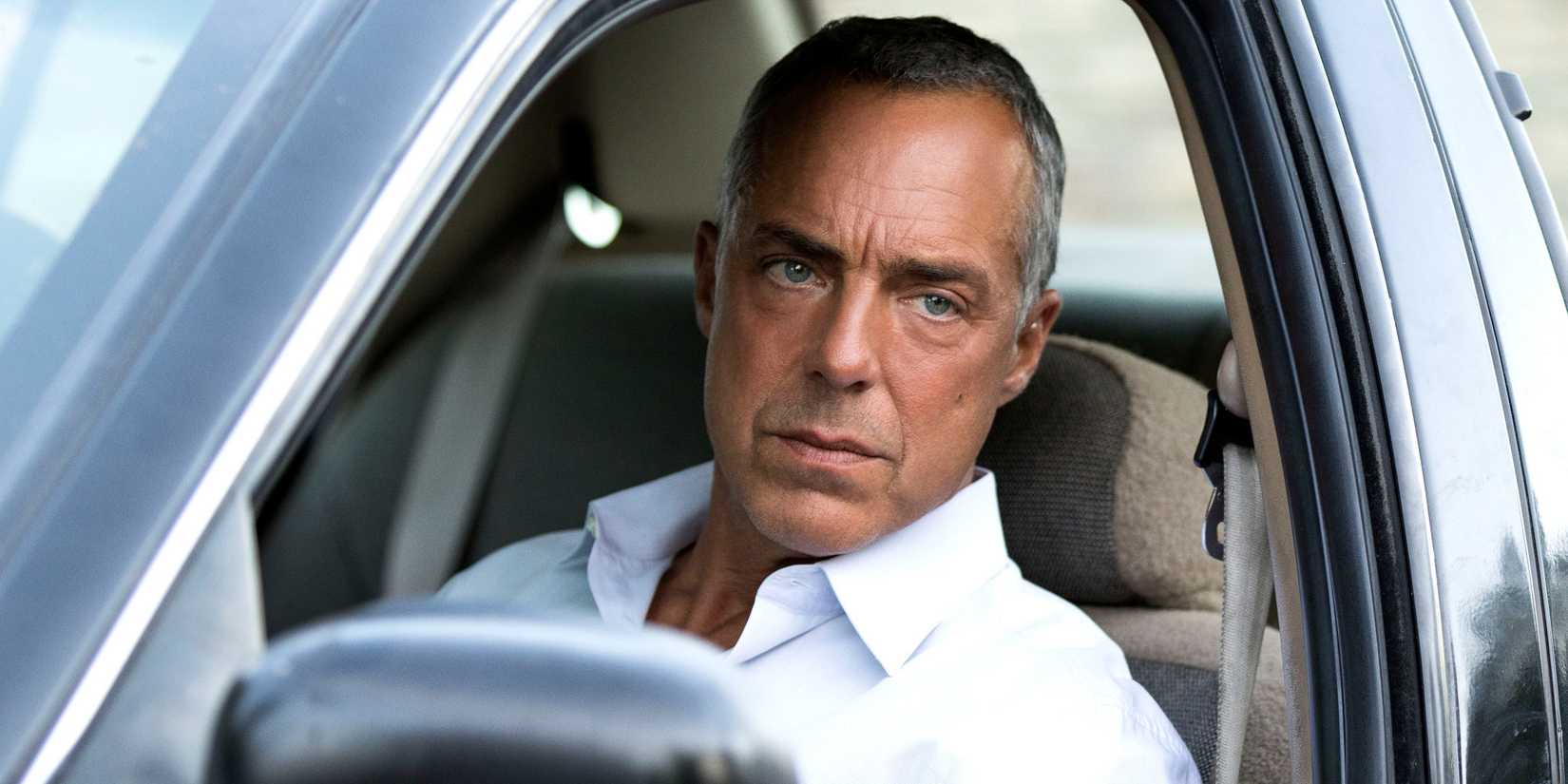 Harry Bosch in his car looking out the window serious in Bosch