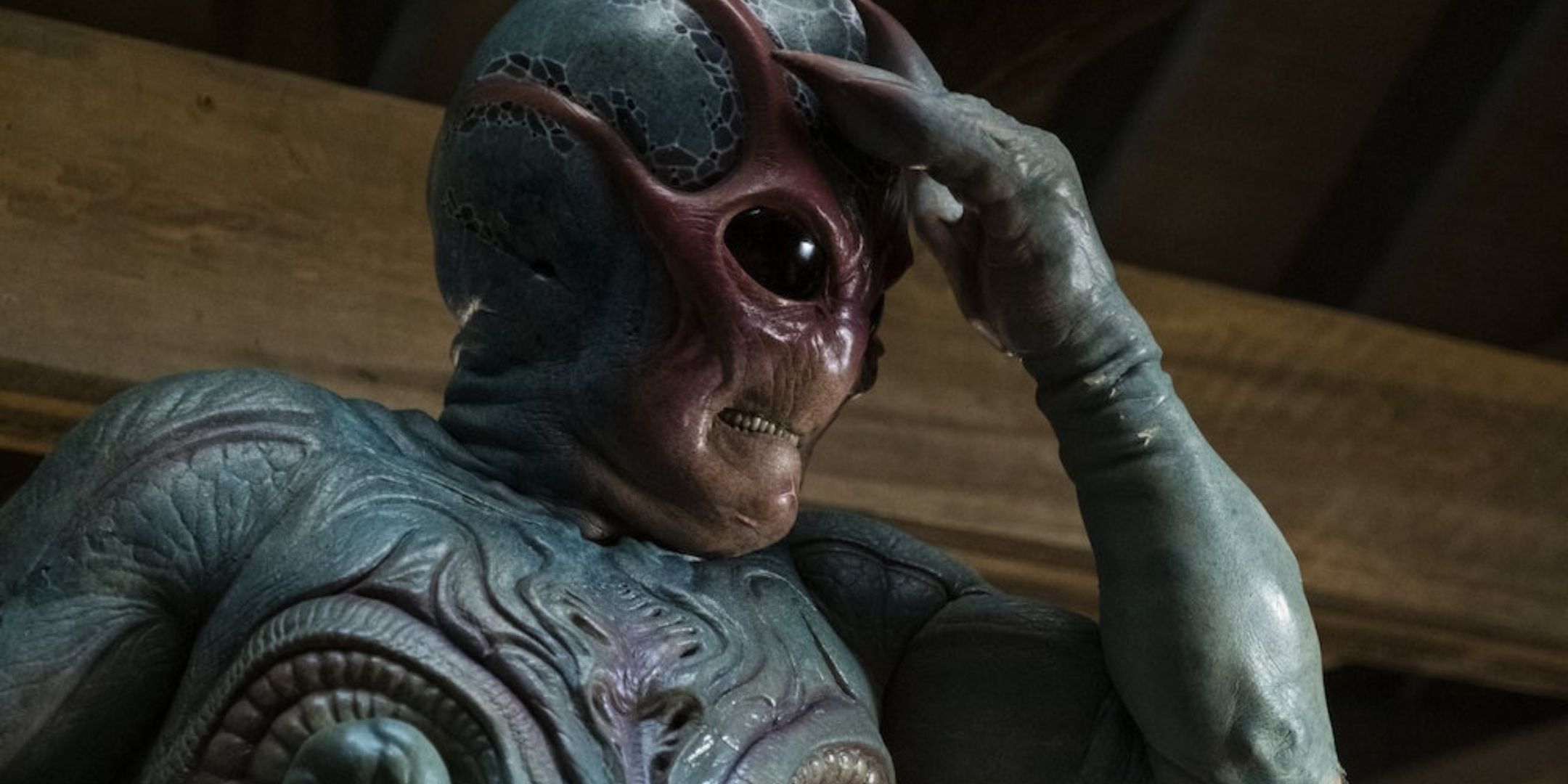 Harry in forma aliena che si massaggia la fronte in Resident Alien
