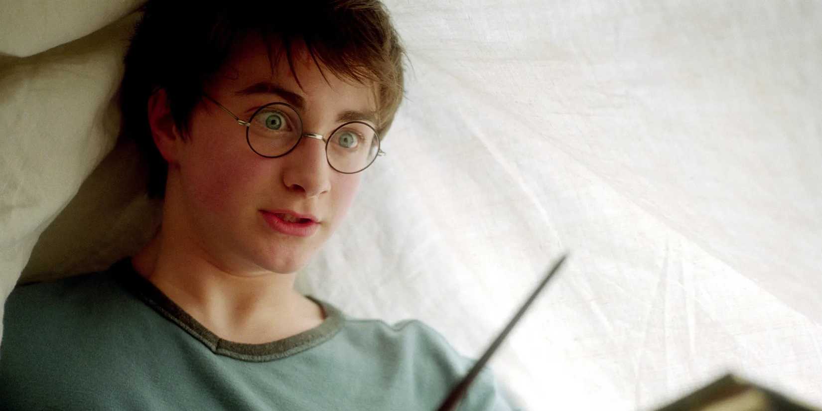 Harry Potter surprised while using Lumos Maxima under a blanket in Harry Potter and the Prisoner of Azkaban.