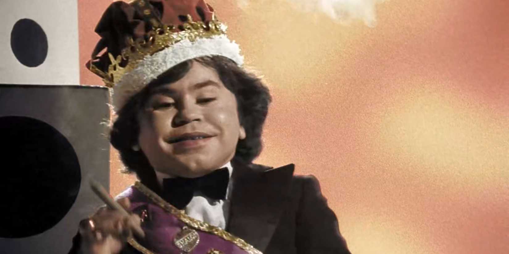 Herve Villechaize smiles delightedly while enjoying a cigar in a scene from Forbidden Zone