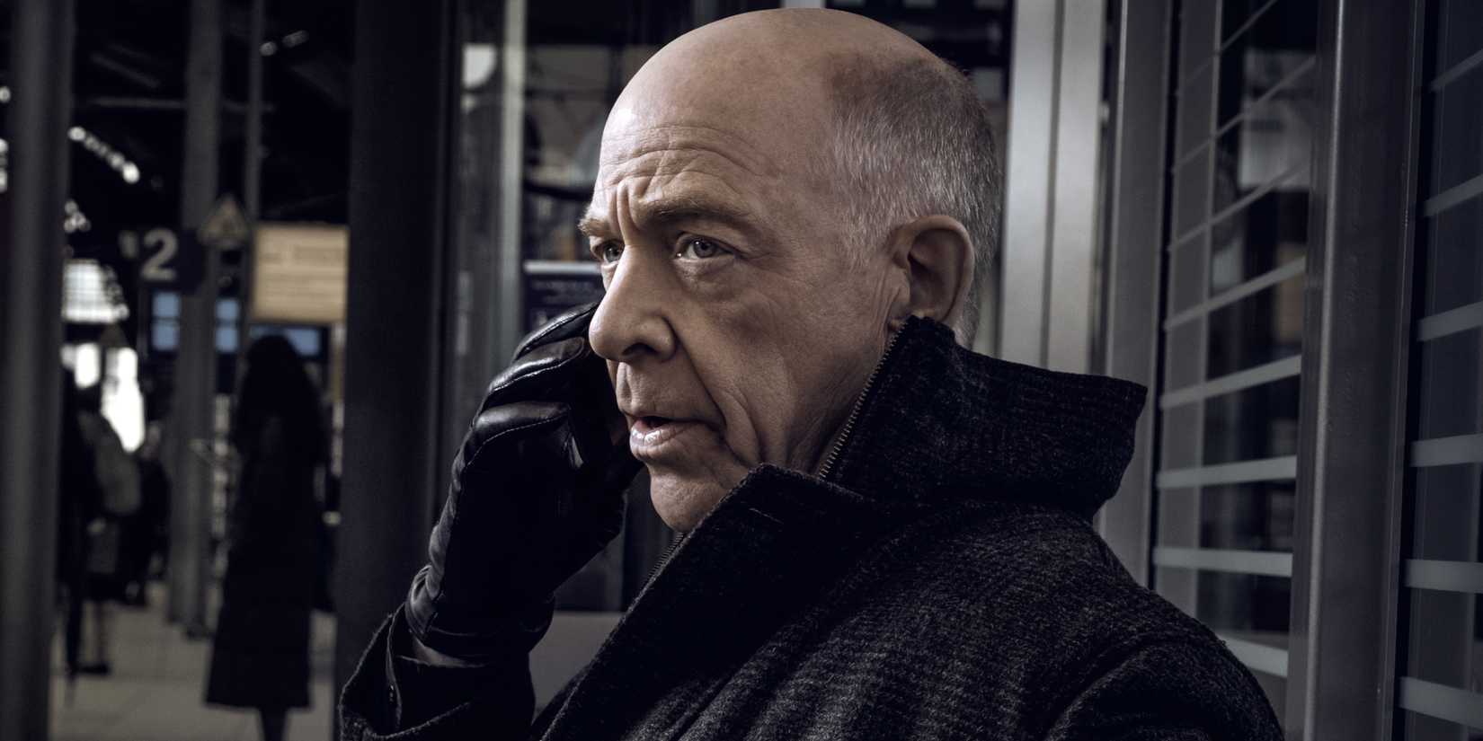 JK Simmons hält ein Telefon im Gegenstück
