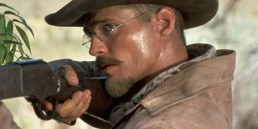 Jason Priestley as Billy pointing a rifle in Tombstone