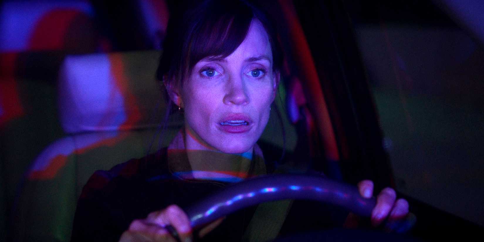 jessica chastain looking worried and sitting in her driver s seat while lit by police lights in the savant