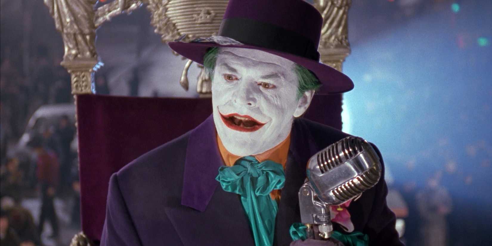 Coringa olhando para fora da tela enquanto segura um microfone em Batman 1989