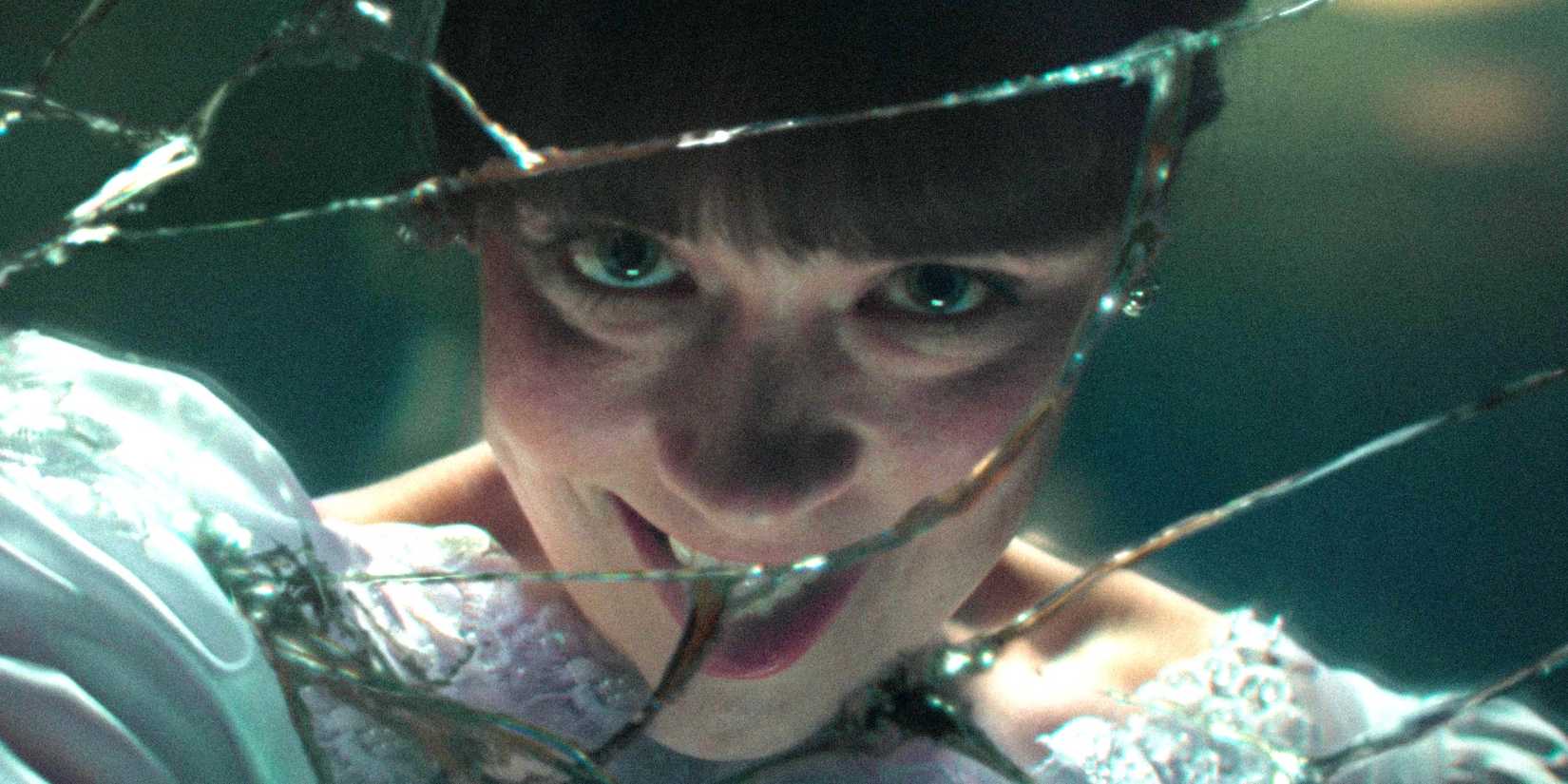 Judy Warren smiling creepily in a broken mirror in The Conjuring: Last Rites