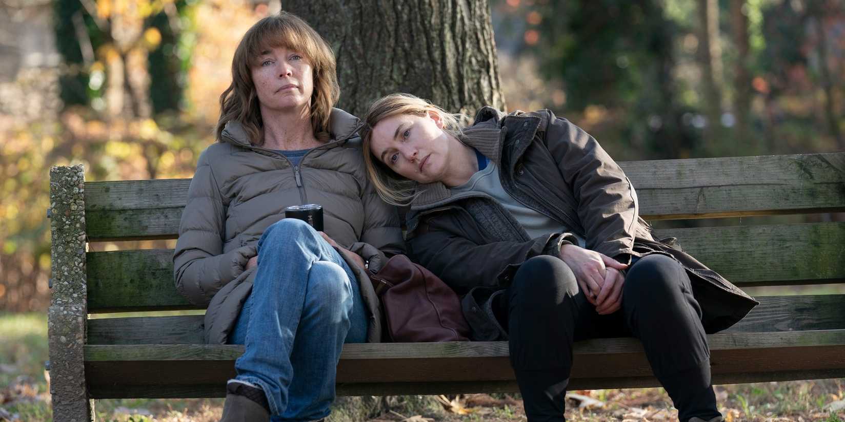 julianne nicholson and kate winslet sitting on a bench from mare of easttown