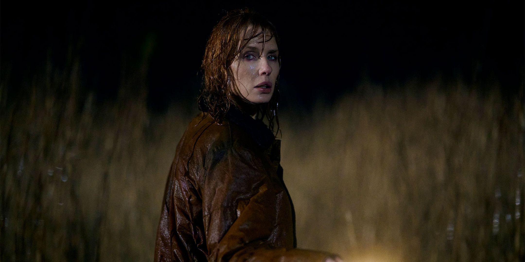 Kelly Reilly as Jackie Ellis in the rain with a flashlight in Under Salt Marsh 