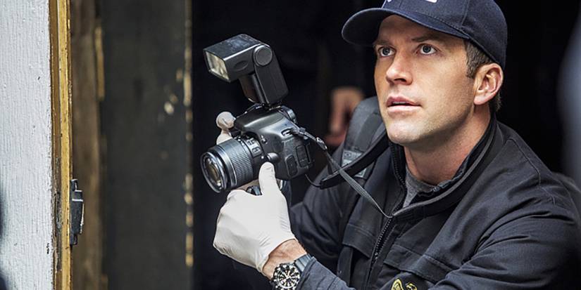 Chris LaSalle (Lucas Black) with a camera as he looks at something off screen in NCIS: New Orleans
