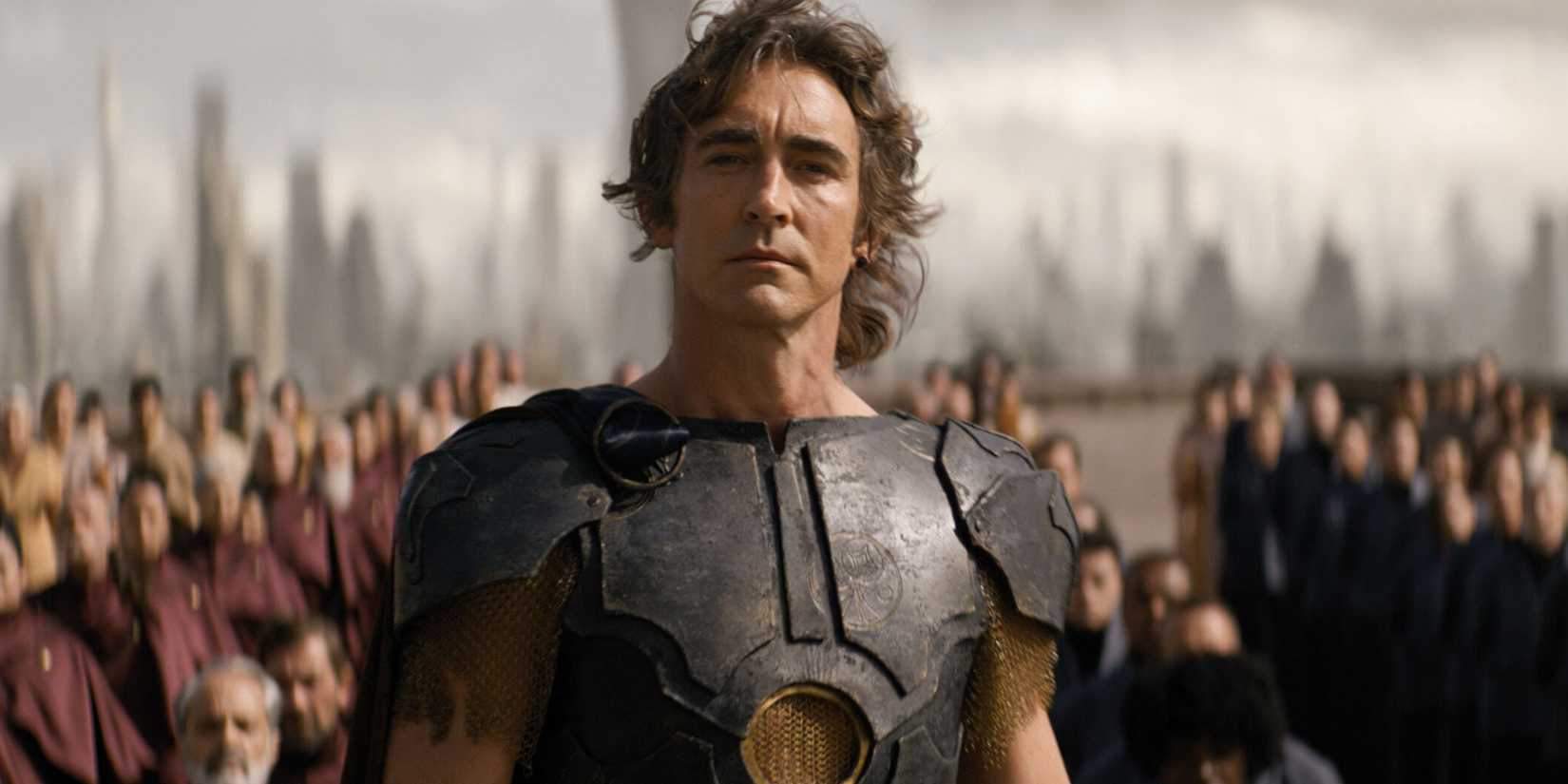 Lee Pace como Irmão Dia em Fundação, em pé nobremente diante de multidões de pessoas enfileiradas
