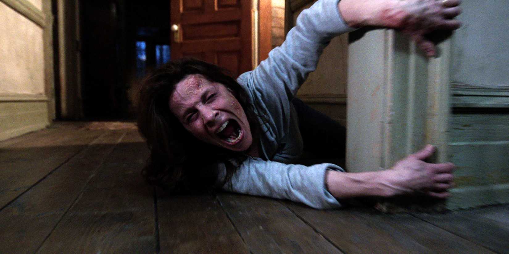 Lili Taylor como Carolyn gritando enquanto se segura em um batente de porta em The Conjuring