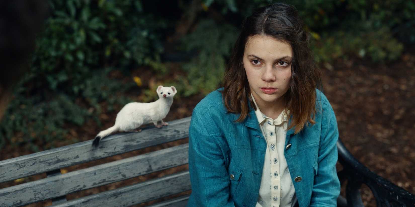 Lyra e Pan sentados em um banco em His Dark Materials