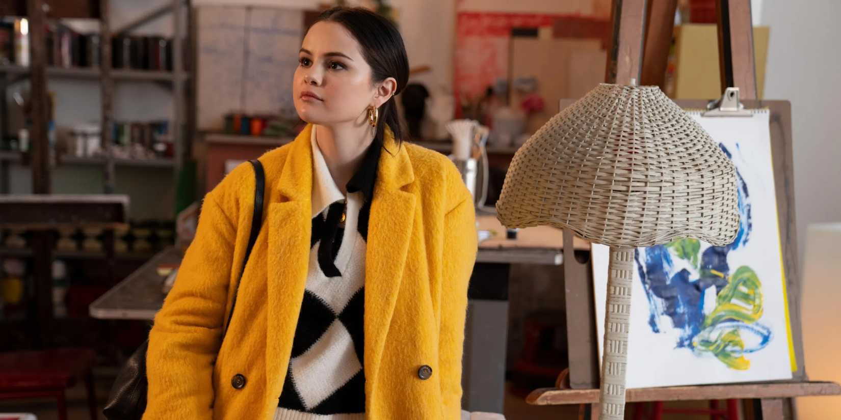 Mabel in a yellow coat in an apartment in Only Murders in the Building