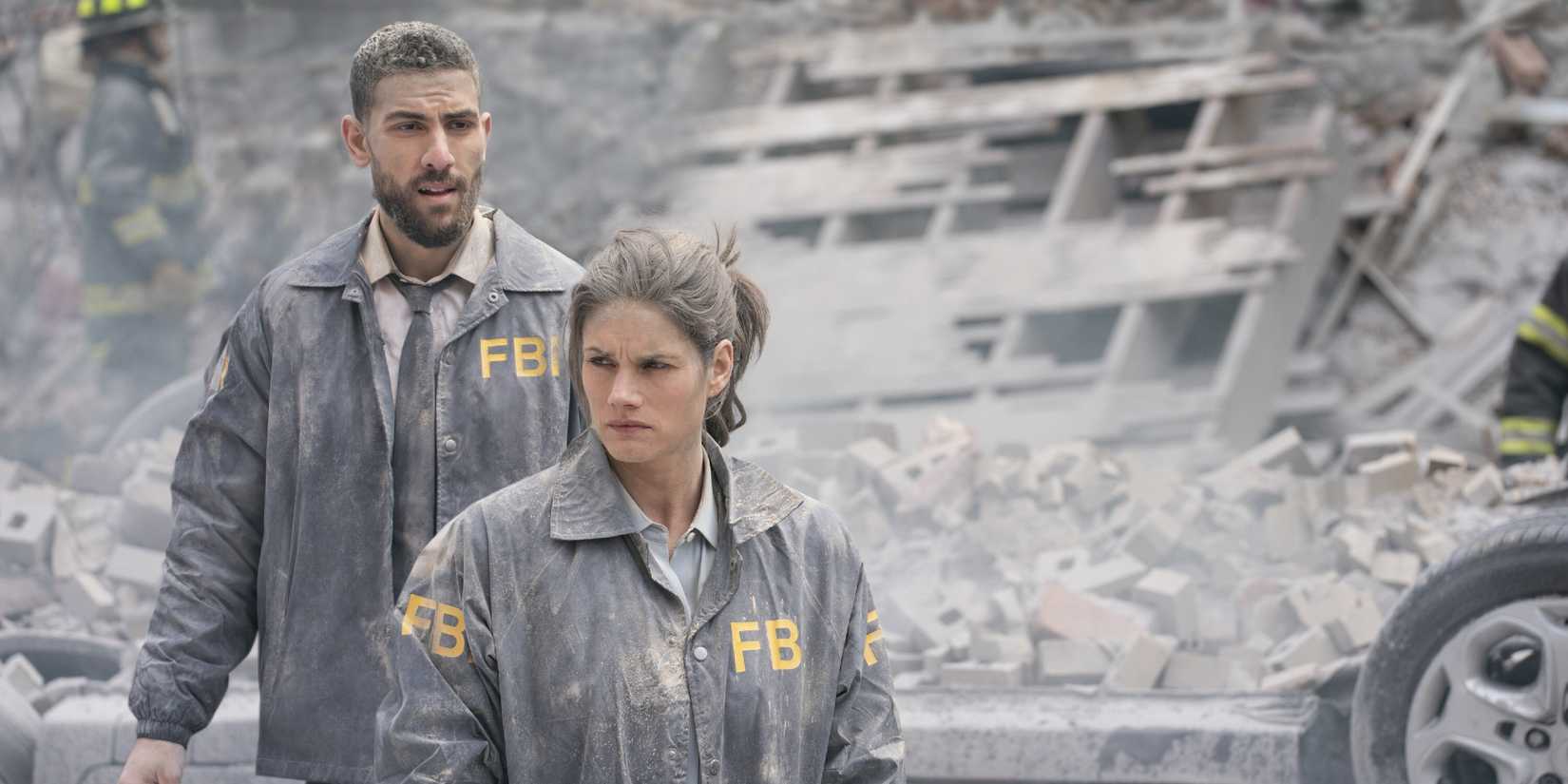 Maggie and Omar covered in dust in the destruction of a building in FBI