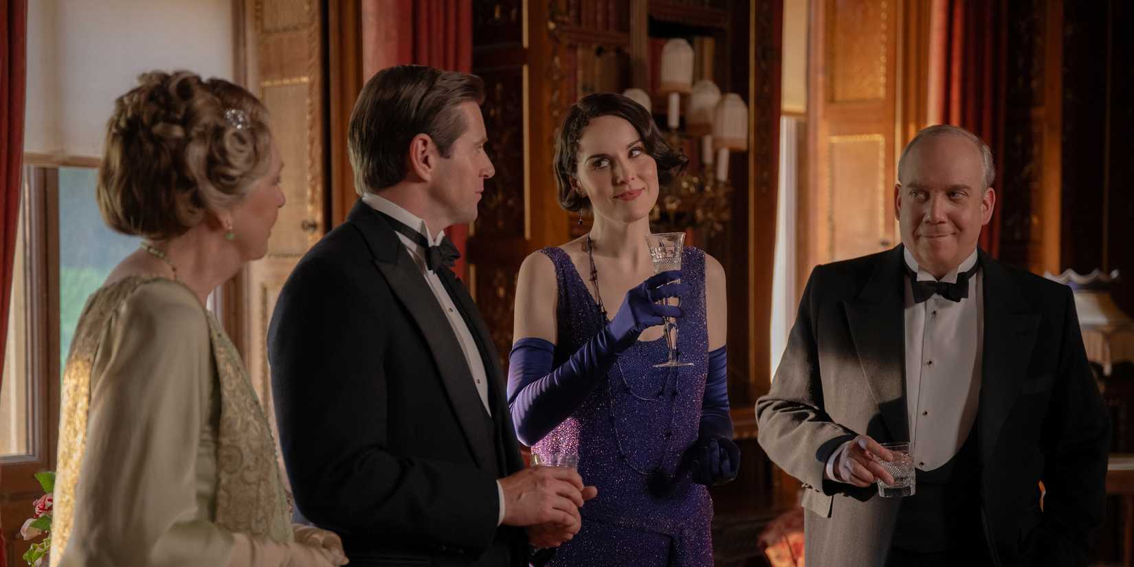 Mary troca um olhar irônico com Tom enquanto Isobel e Harold estão ao lado deles em Downton Abbey: O Grande Final