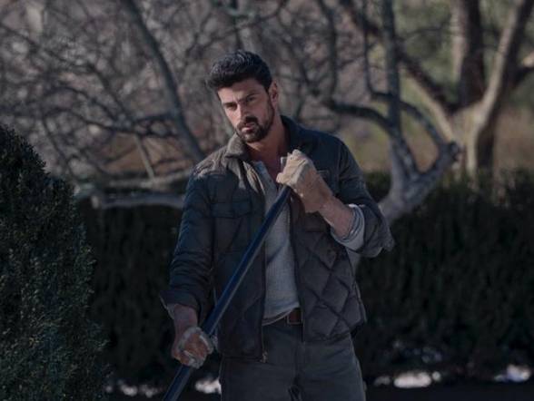 Michele Morrone as Enzo looking suspicious while raking in The Housemaid