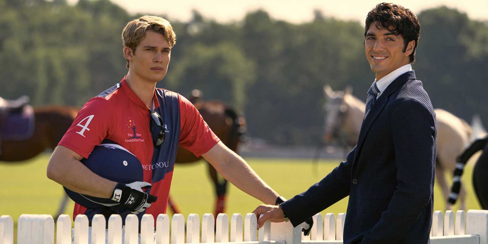 nichoas galitzine s henry and taylor zakhar perez s alex standing on opposite sides of a fence in red white royal blue
