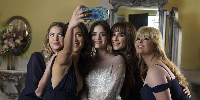 Hanna, Emily, Aria, Spencer, and Ali posing for a photo on Pretty Little Liars
