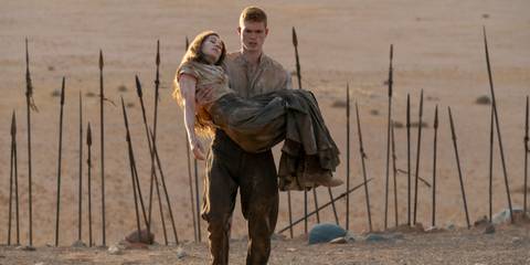 Rand holding an unconscious Moiraine, spears sticking up from the ground behind them, in The Wheel of Time season 3 episode 4