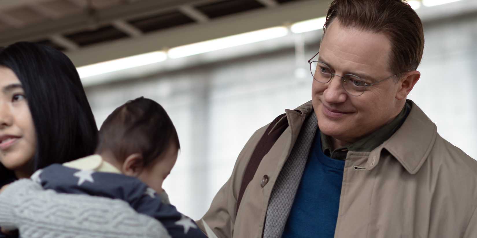 Brendan Fraser smiling at a baby in Rental Family