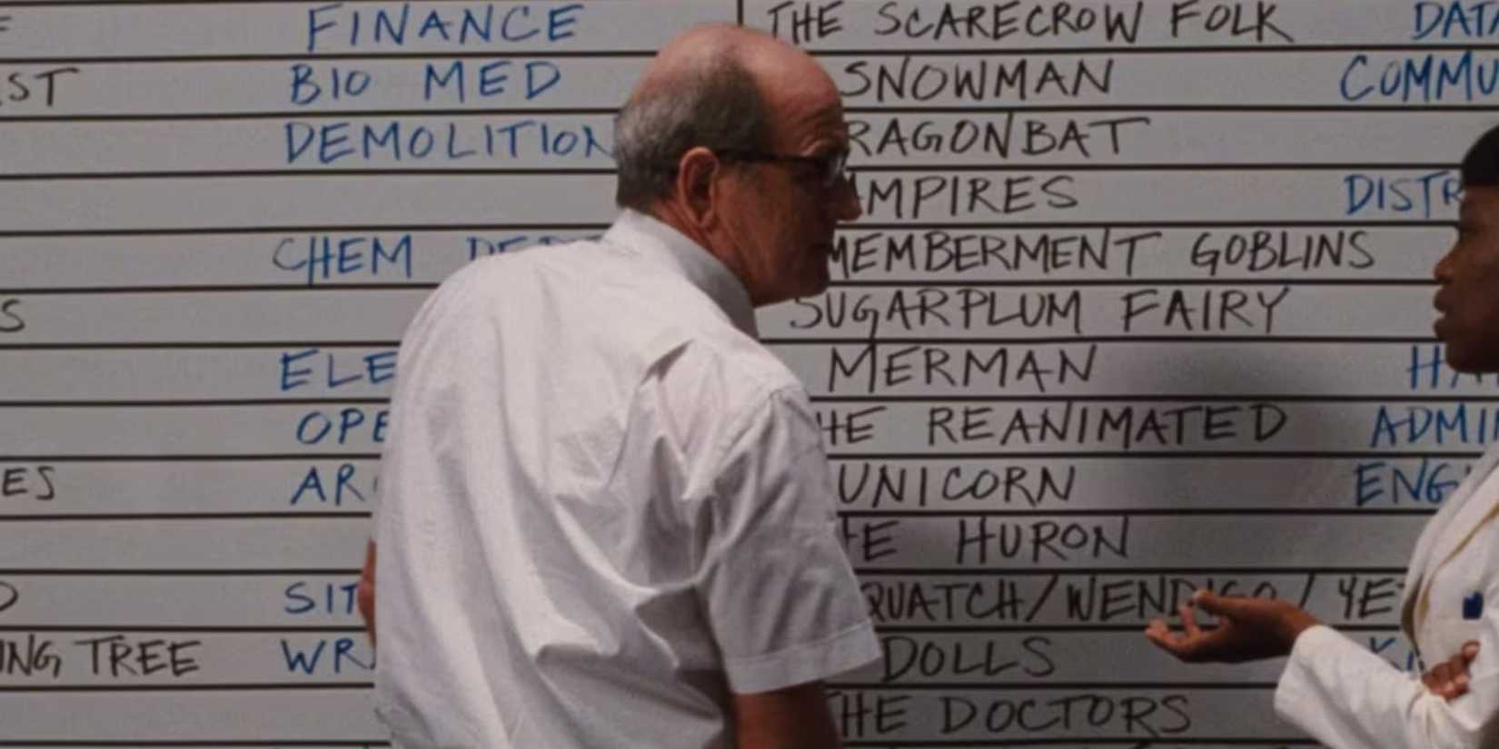 Richard Jenkins as Gary Sitterson by the betting board in Cabin in the Woods