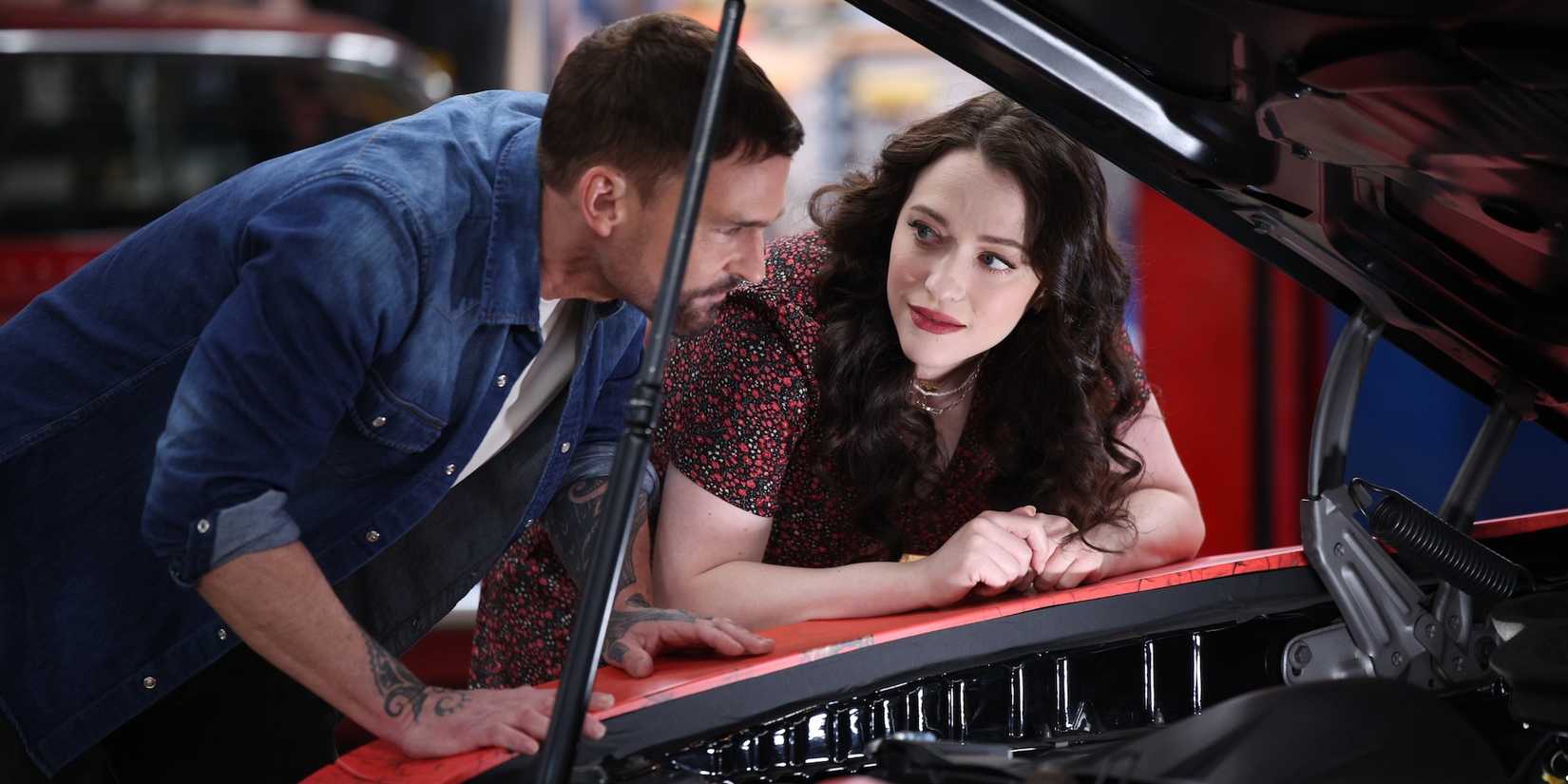 Riley looks longingly at Gabe while both have their heads under a car hood on Shifting Gears