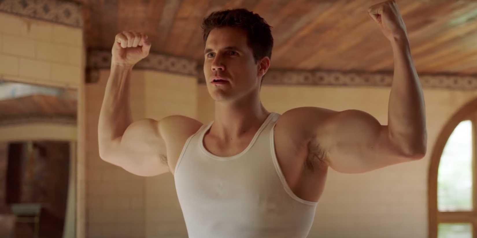 Robbie Amell as Nathan flexing his muscles in Upload season 2
