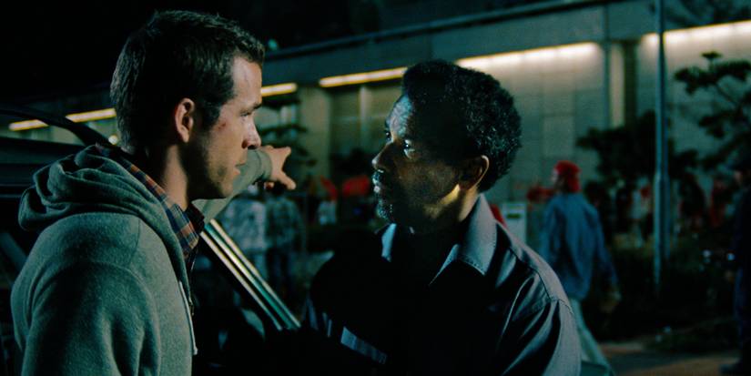 Denzel Washington looks intensely at Ryan Reynolds in Safe House