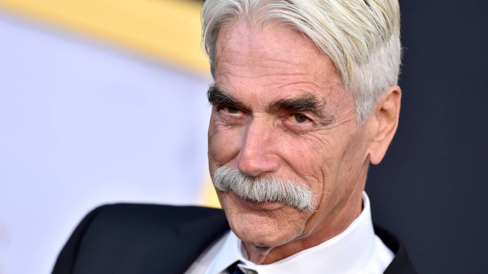 Sam Elliott smiles on the red carpet