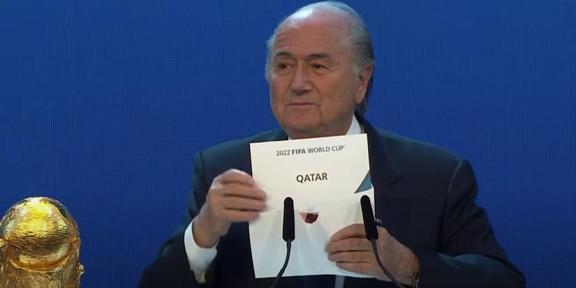 Sepp Blatter holding Qatar envelope next to FIFA World Cup trophy in FIFA Uncovered