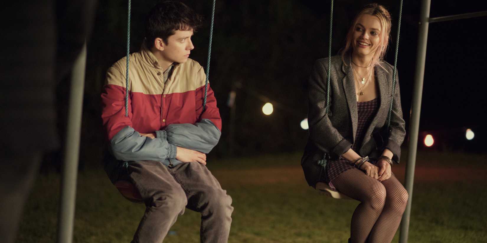 Asa Butterfield como Otis Milburn e Emma Mackey como Maeve Wiley sentados em balanços em Sex Education.