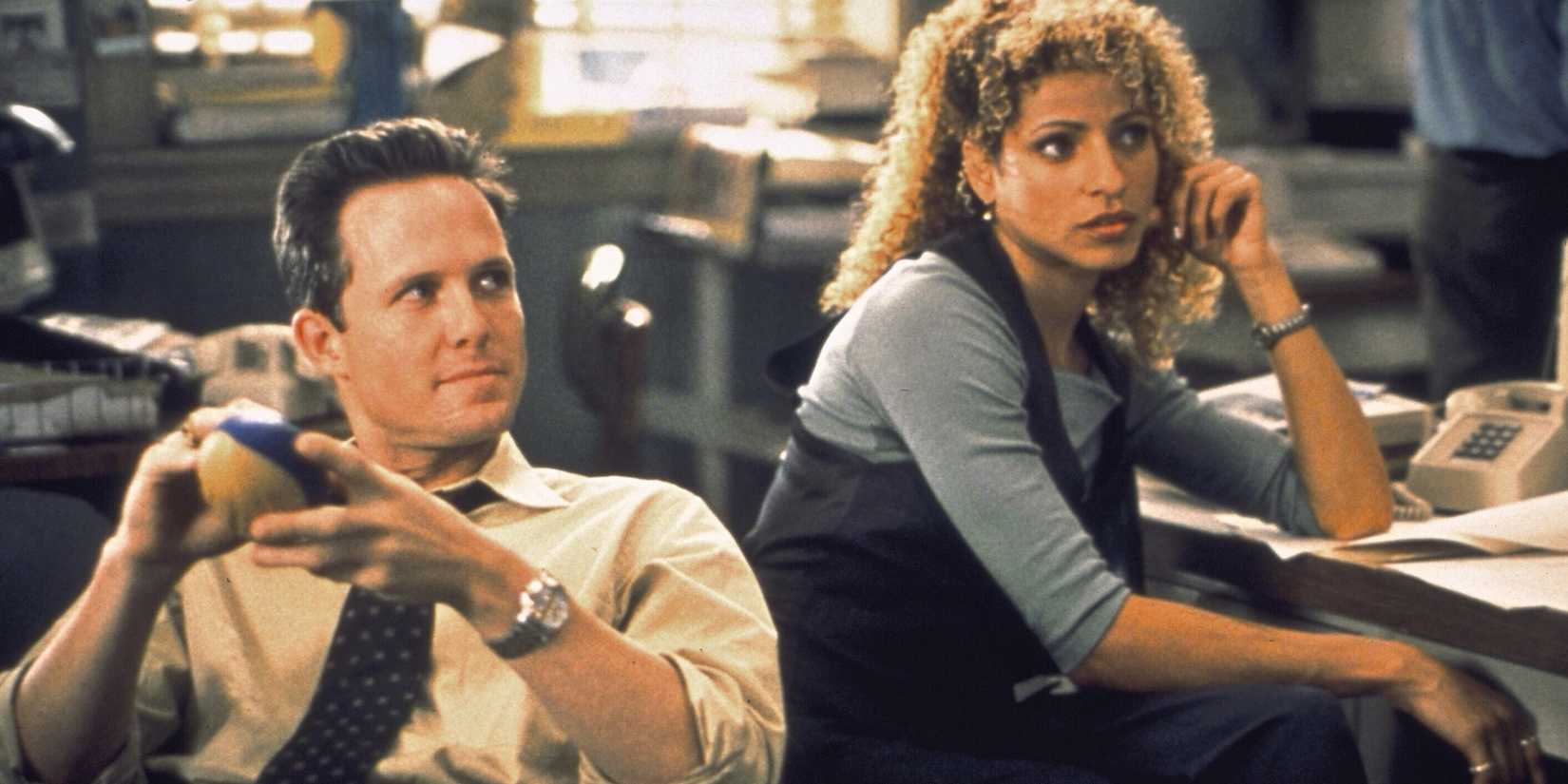 Detectives Cassidy (Dean Winters) and Jeffries (Michelle Hurd) at their desks and looking at someone off camera in Law & Order: SVU season 1