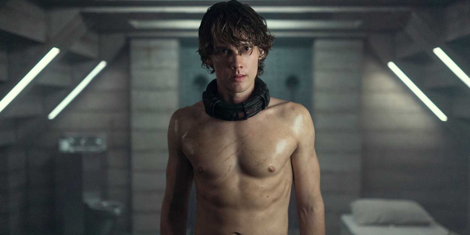 Tyler standing shirtless and with a collar around his neck in Wednesday season 2
