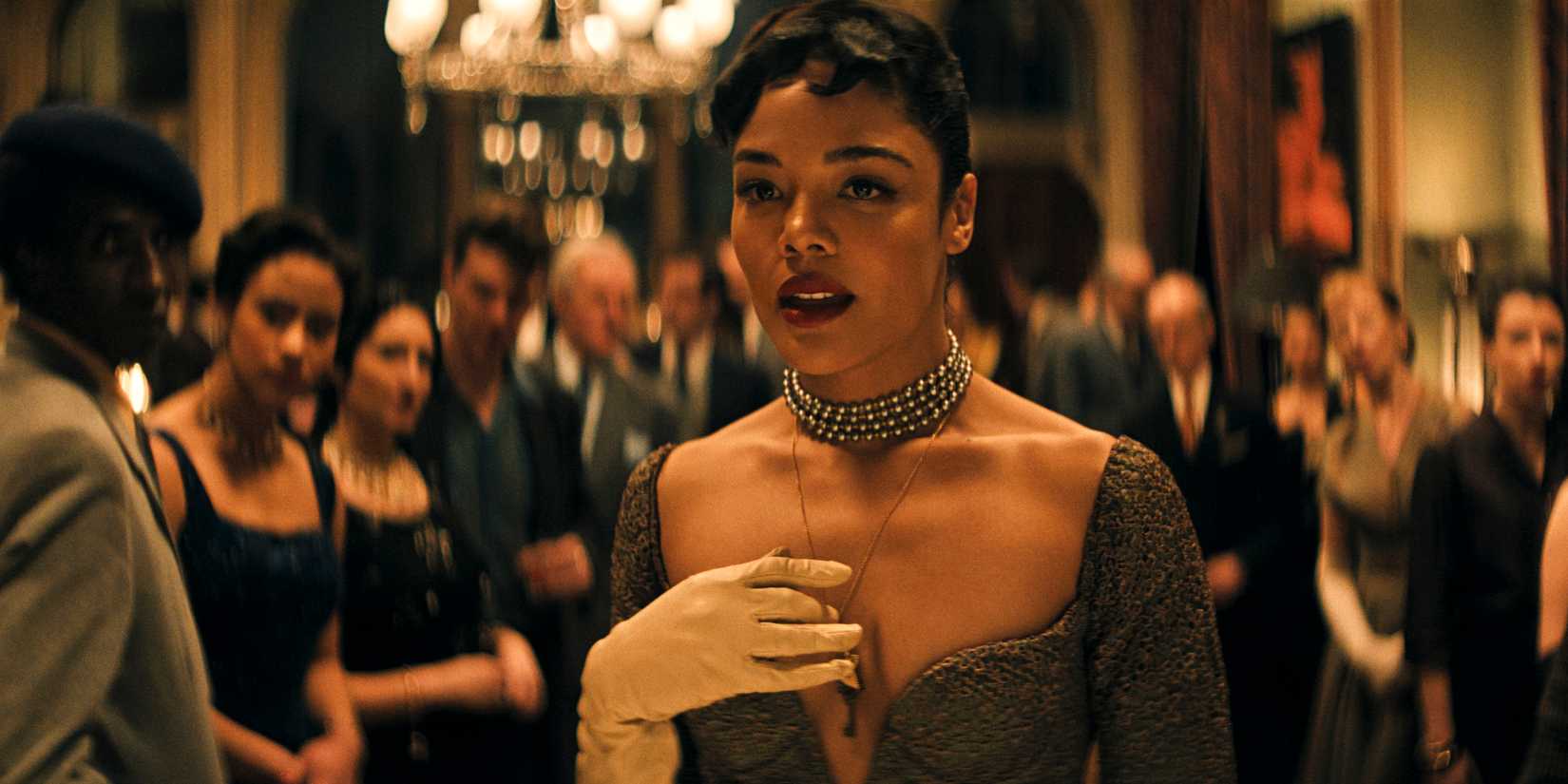 Tessa Thompson holds her hand to her chest in Hedda
