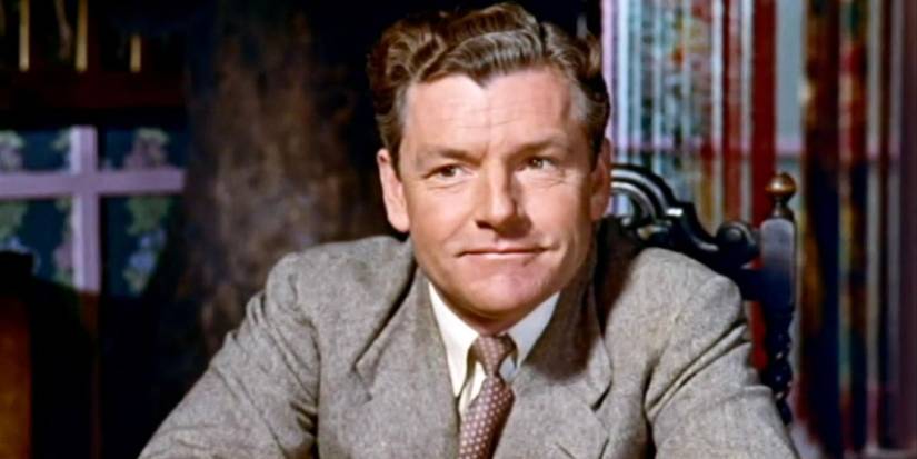 Hannay smiles while looking at someone in the 1959 version of The 39 Steps