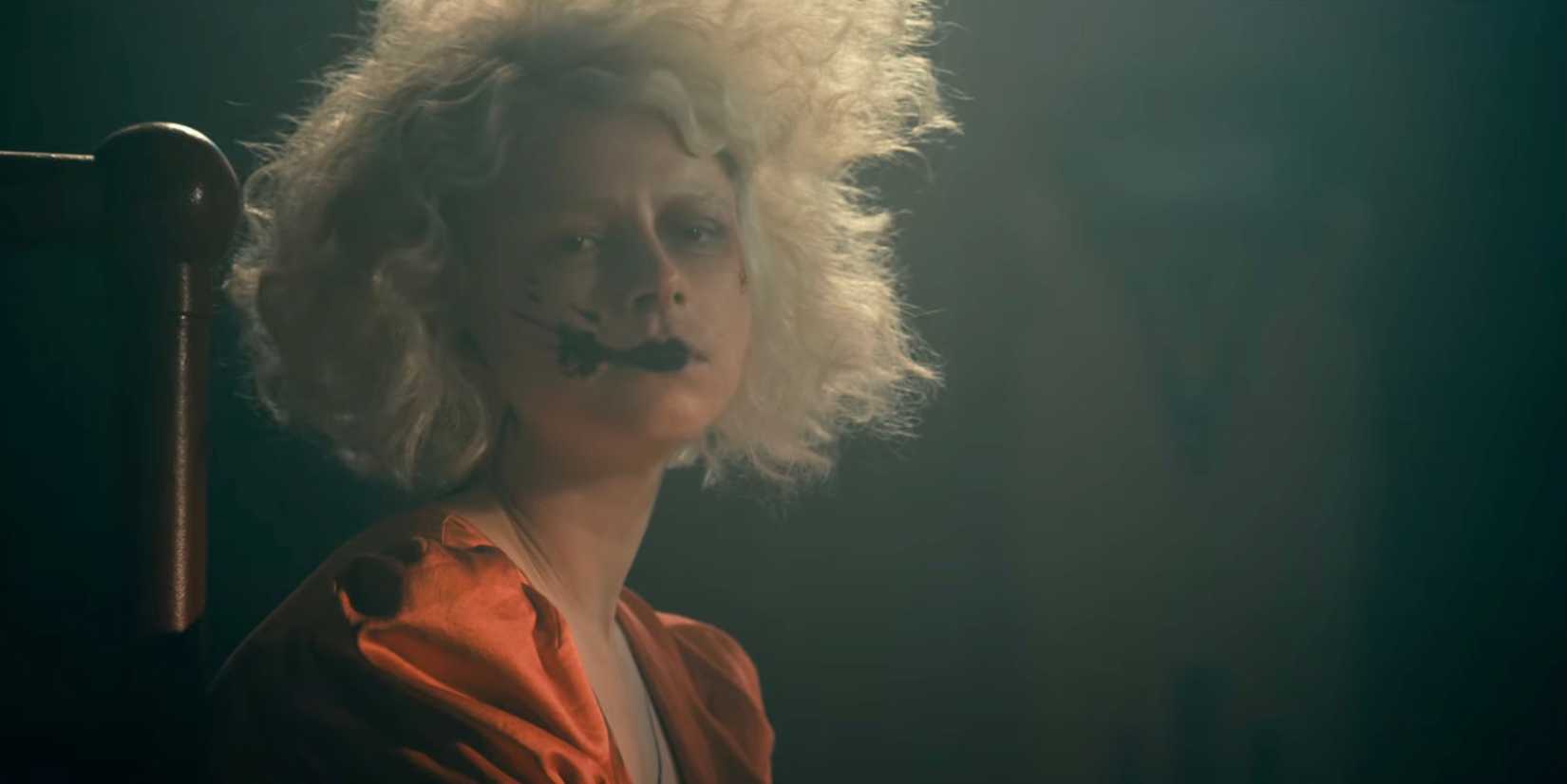 Jessie Buckley with ink splatter on her face in The Bride